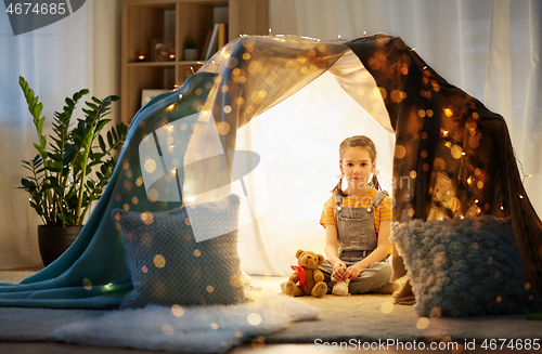 Image of little girl with toys in kids tent at home