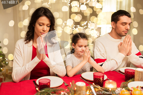 Image of family praying before meal at christmas dinner
