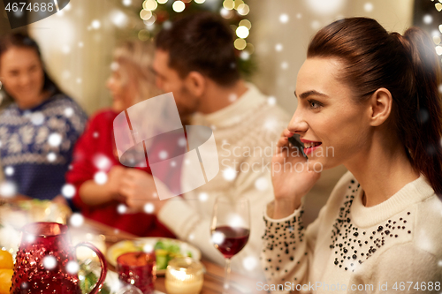 Image of woman calling on smartphone at christmas dinner