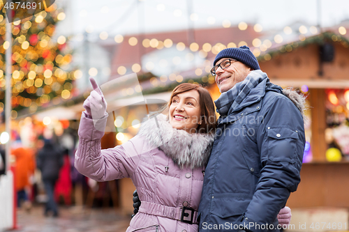 Image of happy senior couple hugging at christmas market