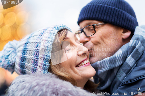 Image of close up of happy senior couple kissing in winter