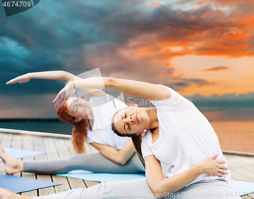 Image of women making yoga exercises outdoors