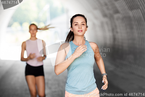 Image of young women or female friends running outdoors