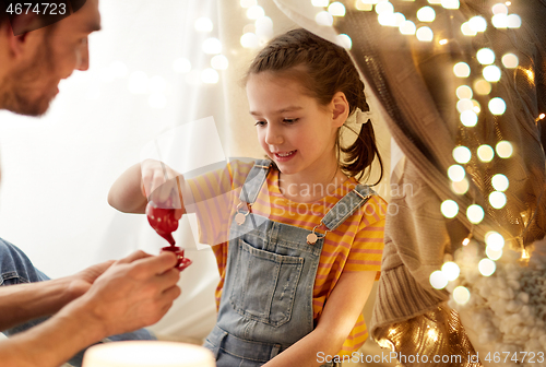 Image of family playing tea party in kids tent at home