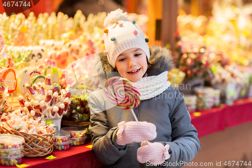 Image of girl with lollipop at christmas market candy shop