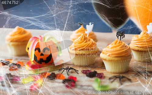 Image of halloween party cupcakes and candies on table