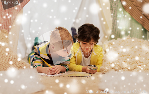 Image of boys with magnifier and map in kids tent at home