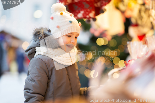 Image of happy little girl at christmas market in winter