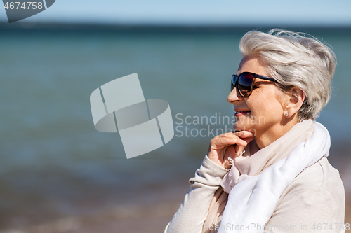 Image of portrait of senior woman in sunglasses on beach