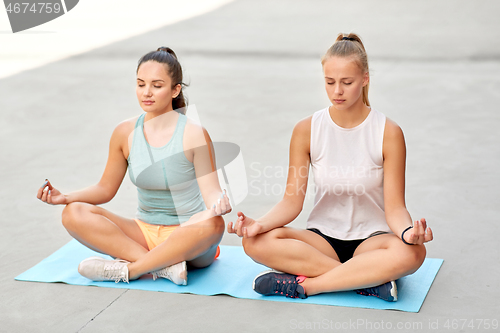 Image of women doing yoga and meditating in lotus pose