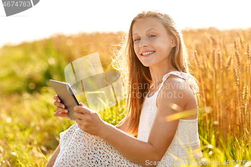 Image of smiling with tablet computer on cereal field