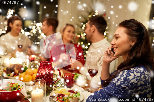 Image of woman calling on smartphone at christmas dinner