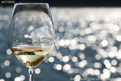 Image of Close-up wineglass and blue sea