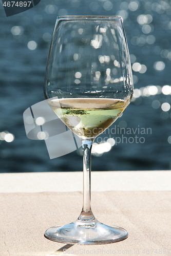 Image of Close-up wineglass and blue sea