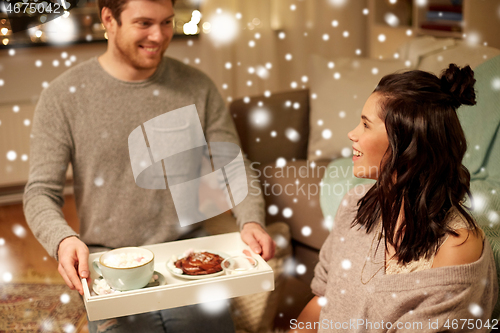 Image of happy couple with food on tray at home