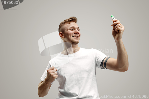 Image of Happy man looking at pregnancy test at studio