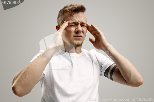 Image of Man having headache. Isolated over gray background.