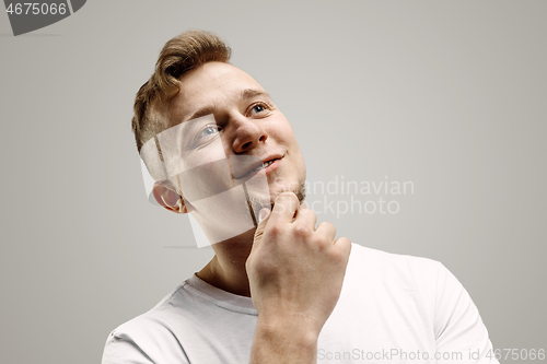 Image of The happy businessman standing and smiling against gray background.