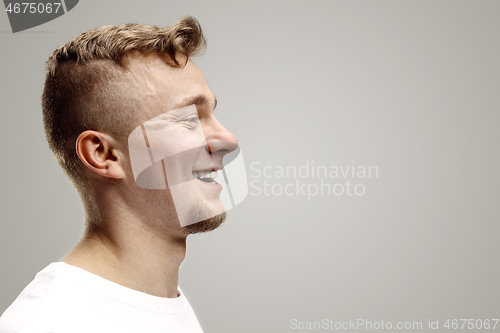 Image of The happy businessman standing and smiling against gray background.