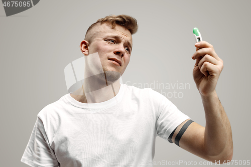 Image of Upset man looking in pregnancy test. Frustrated model