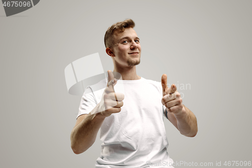 Image of Stylish handsome young man pointing at studio