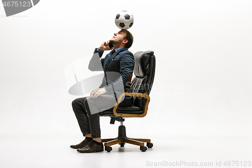 Image of Businessman with football ball in office