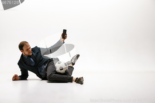 Image of Businessman with football ball in office