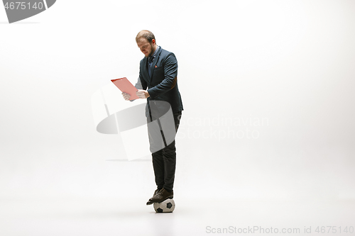 Image of Businessman with football ball in office