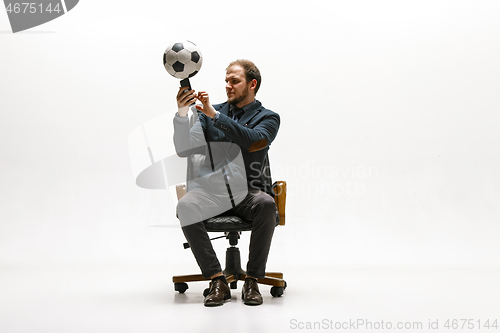 Image of Businessman with football ball in office