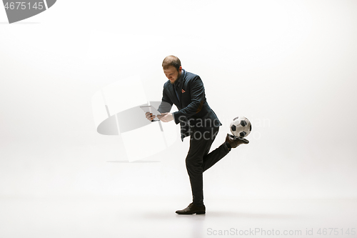 Image of Businessman with football ball in office