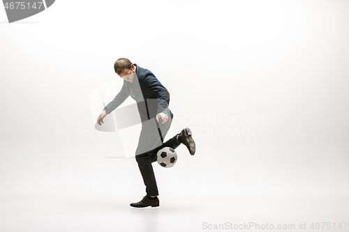 Image of Businessman with football ball in office