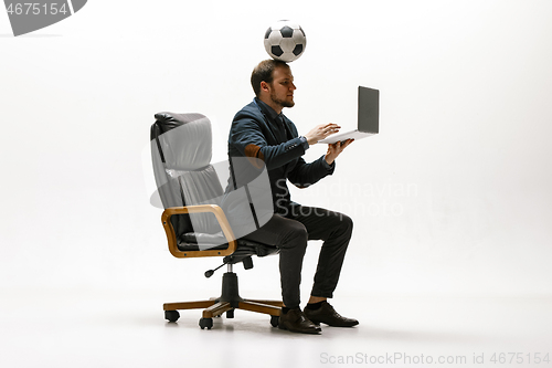 Image of Businessman with football ball in office