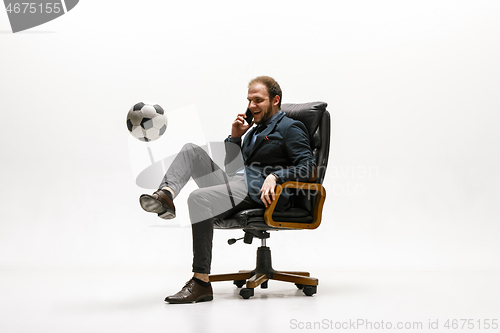 Image of Businessman with football ball in office