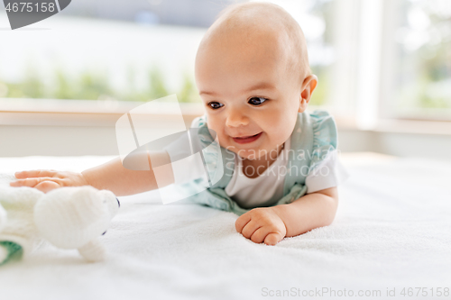 Image of sweet baby girl lying on white blanket