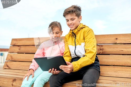 Image of children with tablet computer sitting on bench