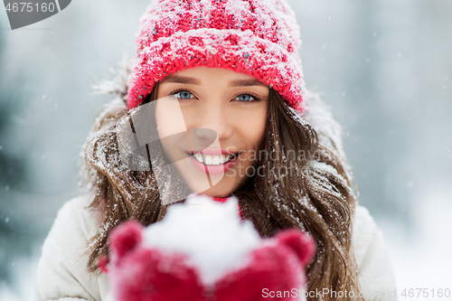 Image of portrait of young woman with snow in winter park