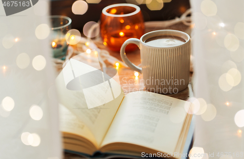 Image of book and cup of coffee or hot chocolate on table