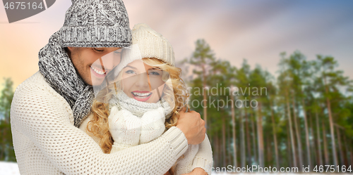 Image of couple hugging over winter forest background