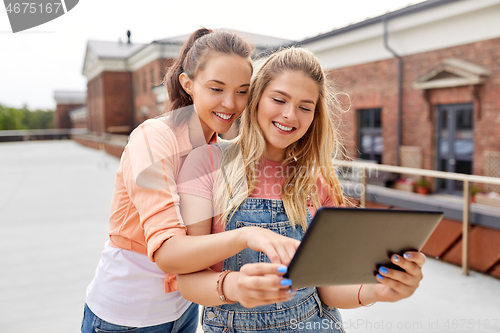 Image of teenage girls with tablet computer on roof top