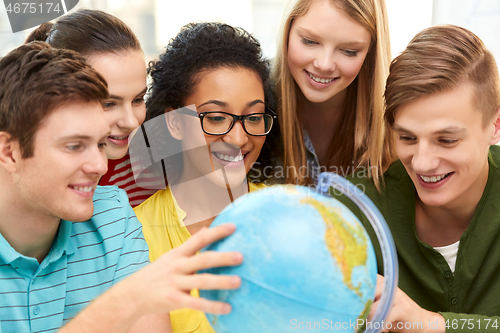 Image of happy high school students looking at earth globe