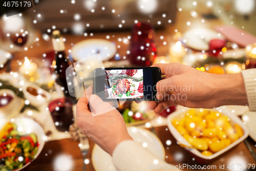 Image of hands photographing food at christmas dinner