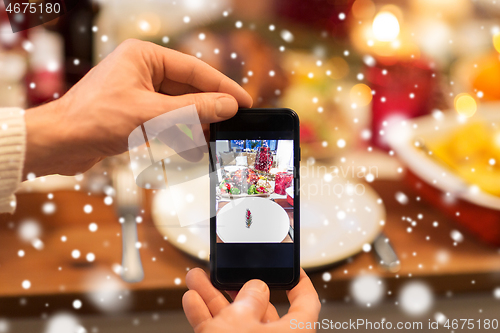 Image of hands photographing food at christmas dinner