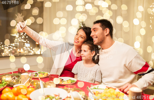 Image of happy family taking selfie at christmas dinner