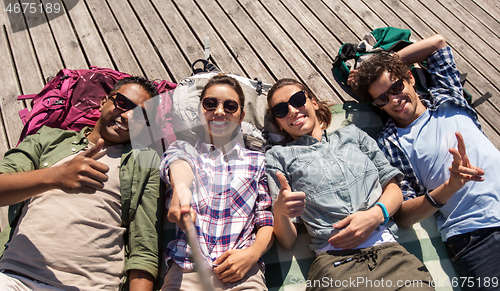 Image of friends or tourists with backpacks taking selfie