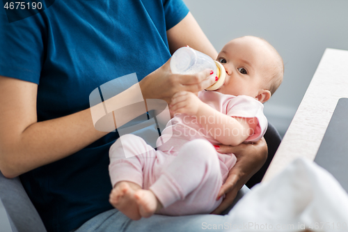 Image of close up of mother feeding baby with milk formula