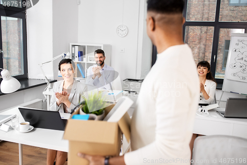 Image of colleagues applauding to male office worker