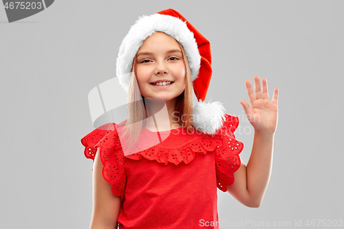 Image of smiling girl in snata helper hat waving hand