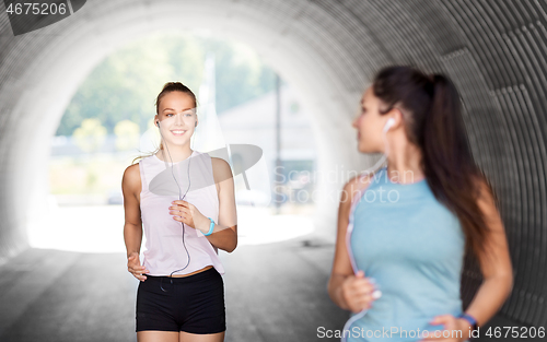 Image of women or female friends with earphones running