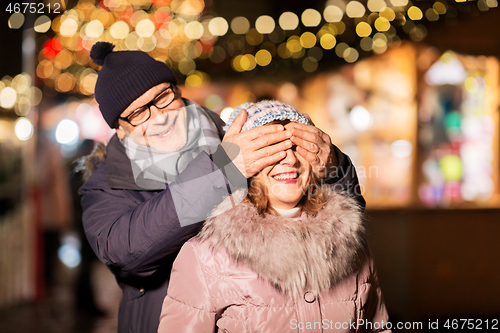 Image of happy senior couple at christmas market