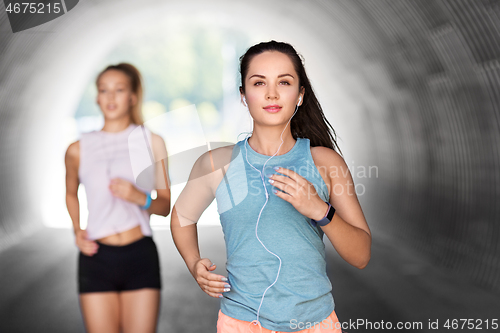 Image of women or female friends with earphones running
